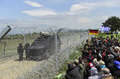 国境のフェンス越しに向かい合うマケドニア兵士と難民・移民たち。(c)AFP/Bulent Kilic