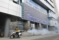 韓国・大邱の新天地イエス教会前で除菌スプレーを噴射する保健当局の職員（2020年2月21日撮影）。(c)Jung Yeon-je / AFP