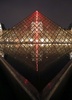 パリ（Paris）のルーブル（Louvre）美術館にあるガラスのピラミッドに設置された、赤いネオンライトを使ったクロード・レベック（Claude Leveque）氏による作品（2014年4月2日撮影）。(c)AFP/FRANCOIS GUILLOT