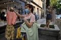 中国・湖北省武漢にある衣料品店の外で衣服を持つ店員ら（2020年8月5日撮影）。(c)Hector RETAMAL / AFP