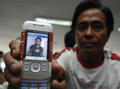 フィリピンの首都マニラ（Manila）にあるフェリー運航会社「Sulpicio Line」本社で、行方不明となっている婚約者の写真を見せる男性（2008年6月24日撮影）。(c)AFP/JES AZNAR