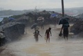 バングラデシュのウキヤにある難民キャンプで、ミャンマーを逃れたイスラム系少数民族ロヒンギャの子どもが雨の中で水を運ぶ様子（2017年10月12日撮影、資料写真）。(c)AFP PHOTO / Munir UZ ZAMAN