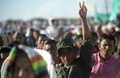 コロンビア西部エルディアマンテにある「コロンビア革命軍（FARC）」のキャンプで、大画面で放映された和平協定調印式典の様子を見守ったFARCメンバーら（2016年9月26日撮影）。(c)AFP/RAUL ARBOLEDA