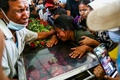 ミャンマー・ヤンゴンで、軍事クーデーターに抗議するデモの最中に死亡した夫の遺体を納めたひつぎにもたれかかり涙を流す女性（2021年3月5日撮影）。(c)STR / AFP