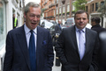 英ロンドンの英独立党（UKIP）本部近くを談笑しながら歩くナイジェル・ファラージ党首（当時、左）と大口献金者の実業家アーロン・バンクス氏（2015年5月15日撮影、資料写真）。(cAFP PHOTO / JUSTIN TALLIS