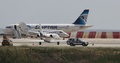 キプロス・ラルナカのラルナカ国際空港で、エジプト航空のエアバスA320型機のそばを通り過ぎる治安部隊の車両（2016年3月29日撮影）。(c)AFP
