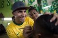 ブラジル・リオデジャネイロ（Rio de Janeiro）の理髪店で、男性客の後頭部にサッカー男子ブラジル代表のネイマール（Neymar da Silva Santos Junior）選手の肖像を施す理髪師（2014年6月27日撮影）。(c)AFP/YASUYOSHI CHIBA