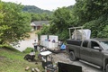 川の氾濫で水没した自宅を眺める人。米ケンタッキー州ジャクソンで（2022年7月28日撮影）。(c)LEANDRO LOZADA / AFP