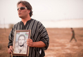 リビアの首都トリポリ（Tripoli）のアブサリム（Abu Salim）刑務所で、カダフィ政権に同刑務所で殺害されたとみられる兄弟の写真を掲げる男性（2011年9月25日撮影）。(c)AFP/LEON NEAL