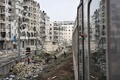シリア・アレッポ東部で、荒廃した地区を走行する列車を見る子どもたち（2017年1月25日撮影）。(c)AFP/George OURFALIAN