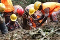 土砂崩れが発生したバングラデシュ南東部のランガマティで、行方不明者の捜索を行う救急隊員ら（2017年6月14日撮影）。(c)AFP