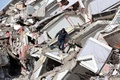 地震に見舞われたトルコ・カフラマンマラシュで、がれきの上を歩く男性（2022年2月7日撮影）。(c)Adem ALTAN / AFP