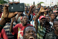 ハイチの首都ポルトープランス（Port-au-Prince）で、崩壊した大統領官邸前で、フェンスの内側に姿を現したルネ・プレバル（Rene Preval）ハイチ大統領に向かって叫ぶ市民（2010年1月30日撮影）。(c)AFP/JEAN-PHILIPPE KSIAZEK