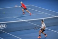 全豪オープンテニス、男子シングルス4回戦。リターンを狙う錦織圭（上）とロジャー・フェデラー（2017年1月22日撮影）。(c)AFP/WILLIAM WEST