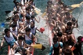 香港（Hong Kong）で行われた毎年恒例「ドラゴンボート（龍舟）フェスティバル（Dragon Boat Festival）」で、互いに水を掛け合うレース参加者ら（2014年6月2日撮影）。(c)AFP/Philippe Lopez