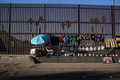 メキシコ北西部メヒカリで、国境フェンスを商品陳列棚として使う露天商（2017年2月14日撮影）。(c)AFP/Guillermo Arias