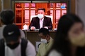 韓国ソウルの駅で、マスクを外す北朝鮮の金正恩総書記を映したテレビ画面（2022年5月12日撮影）。(c)Anthony WALLACE / AFP 