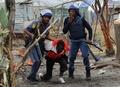 南アフリカのマリカナ（Marikana）にある英資源大手ロンミン（Lonmin）が開発するプラチナ鉱山で鉱山労働者（中央）を取り押さえる警察官ら。この鉱山ではこの写真が撮影される約1か月前の2012年8月16日に警察の発砲で鉱山労働者34人が死亡していた（2012年9月15日撮影、資料写真）。(c)AFP/ALEXANDER JOE