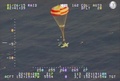 米ハワイ沖で、パラシュートを使って海上への不時着を試みる小型機。米沿岸警備隊公開の映像より（2015年1月26日提供）。(c)AFP/HANDOUT/US COAST GUARD