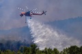 ギリシャ西部ペロポネソス半島にあるオリンピアの古代遺跡近くの山火事で消火活動にあたるヘリコプター（2021年8月4日撮影）。(c)STR / Eurokinissi / AFP