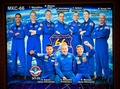 ロシア・モスクワ郊外のミッションコントロールセンターのモニターに映し出された前澤友作氏（前列右）ら（2021年12月20日撮影）。(c)Alexander NEMENOV / AFP