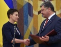 ウクライナの首都キエフで、ロシアから帰国したナディア・サフチェンコ氏（左）に勲章を授与するペトロ・ポロシェンコ大統領（2016年5月25日撮影）。(c)AFP/GENYA SAVILOV