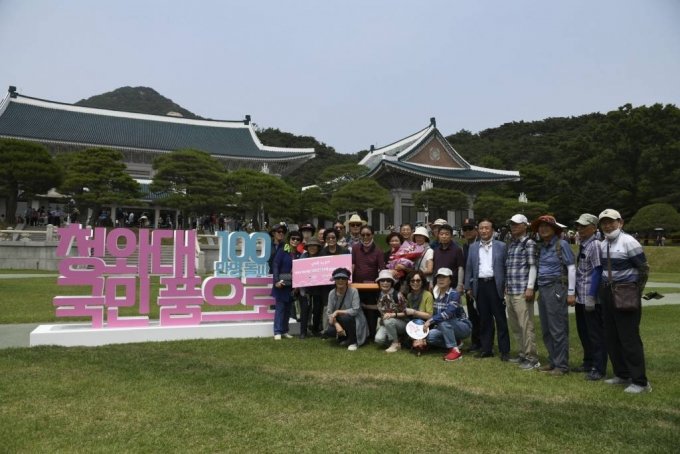開放44日目となる今月22日、大庭園で開かれた「100万人目の青瓦台観覧客」記念行事で100万人目の観覧客に選ばれたキム・ヨンスン氏（2列目の左から3番目）一行が記念撮影をしている（写真=文化財庁）(c)MONEYTODAY