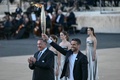 ギリシャ・アテネのパナシナイコ・スタジアムで行われたパリ五輪の聖火引継ぎ式で、聖火トーチを掲げる大会組織委員会のトニー・エスタンゲ会長（右手前、2024年4月26日撮影）。(c)Aris MESSINIS / AFP
