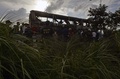 台湾・桃園にある空港へと向かう道路沿いで、衝突・炎上した観光バスを調べる捜査官ら（2016年7月19日撮影）。(c)AFP/Sam YEH