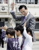 「春の全国交通安全運動中央大会」で小学生と手をつないで横断歩道を歩く麻生太郎（Taro Aso）首相（2009年4月13日撮影）。(c)AFP/Yoshikazu TSUNO