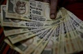 インドの首都ニューデリー近郊の自宅で、500ルピー札を手にする女性（2016年11月8日撮影）。(c)AFP/MONEY SHARMA