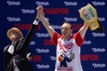 米ニューヨークのコニーアイランドで行われた恒例のホットドッグ早食い大会で優勝したジョーイ・チェスナットさん（右、2022年7月4日撮影）。(c)Yuki IWAMURA / AFP