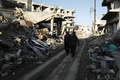 シリアの首都ダマスカス近郊ジョバルで、砲撃の被害を受けた通りを歩く人々（2016年2月24日撮影）。(c)AFP/ABDULMONAM EASSA