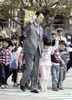 「春の全国交通安全運動中央大会」で小学生と手をつないで横断歩道を歩く麻生太郎（Taro Aso）首相（2009年4月13日撮影）。(c)AFP/Yoshikazu TSUNO