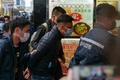 香港・立場新聞の事務所に連れていかれる林紹桐（パトリック・ラム）編集長代理（中央、2021年12月29日撮影）。(c)Daniel SUEN / AFP