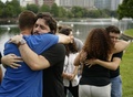 米フロリダ州オーランドのエオラ湖で、銃乱射事件の犠牲者の追悼集会後に抱き合う人々（2016年6月13日撮影）。(c)AFP/MANDEL NGAN