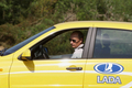 ロシア極東のハバロフスク（Khabarovsk）で、露自動車大手アフトワズ（Avtovaz）の「ラーダ・カリーナ・スポーツ（Lada Kalina Sport）」に乗り込むウラジーミル・プーチン（Vladimir Putin）首相（2010年8月27日撮影）。(c)AFP/RIA-NOVOSTI/ALEXEY DRUZHININ