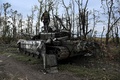 ウクライナ東部イジュームで、放棄されたロシア軍戦車の上に立つウクライナ兵（2022年9月11日撮影）。(c)Juan BARRETO / AFP