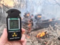 ウクライナ・チェルノブイリ原発から半径30キロ圏内で広がる森林火災の様子と、現場で掲げたガイガーカウンター（2020年4月5日撮影）。(c)Yaroslav EMELIANENKO / AFP