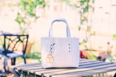 「明治おいしい牛乳」の紙パックを活用し、高齢者によって制作されたアップサイクル商品「MILK BAG」を販売