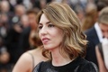 南仏カンヌ（Cannes）で開催中の第66回カンヌ国際映画祭（Cannes Film Festival）で16日、「ある視点」部門に出品されたソフィア・コッポラ（Sofia Coppola）監督作『The Bling Ring』の公式上映が行われた。同作は、2009年、ロサンゼルス（Los Angeles）で10代の若者たちがオーランド・ブルーム（Orlando Bloom）やリンジー・ローハン（Lindsay Lohan）らセレブの自宅を狙って空き巣に入った一連の事件をベースにしている。犯人の1人を演じた英女優エマ・ワトソン（Emma Watson）は「ハリー・ポッター（Harry Potter）」のハーマイオニー（Hermione）役として有名だが、本作で今どきの若者を演じるため、カーダシアン一家やパリス・ヒルトン（Paris Hilton）らが出演するリアリティー番組を何時間も見たという。写真は、レッドカーペットに登場したコッポラ（2013年5月16日撮影）。(c)AFP/VALERY HACHE