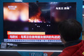 中国・杭州市の商業施設でウクライナ侵攻関連のニュースを見る市民（2022年2月25日撮影）。(c)AFP