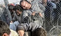 トルコ・アクチャカレの国境検問所付近で、壊された国境のフェンスを越えてトルコ領内に入ろうとするシリア難民たち（2015年6月14日撮影）。(c)AFP/BULENT KILIC