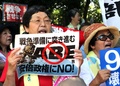 東京の国会議事堂前で、衆議院平和安全法制特別委員会が可決した安全保障関連法案に抗議するデモに参加した市民団体の女性メンバーら（2015年7月15日撮影）。(c)AFP/Yoshikazu TSUNO