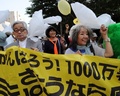 都内で2日、脱原発を求める大規模な集会とデモ行進が行われた。芝公園で行われた集会には主催者発表で東日本大震災による原発事故の被災者やノーベル賞作家の大江健三郎（Kenzaburo Oe）さんら7500人が参加。その後、参加者らは東京電力（TEPCO）本社前などを通るデモ行進を行った。

写真は、デモ行進の先頭を歩く大江健三郎さん（左）と落合恵子（Keiko Ochiai）さん（右、2013年6月2日撮影）。(c)AFP/TOSHIFUMI KITAMURA