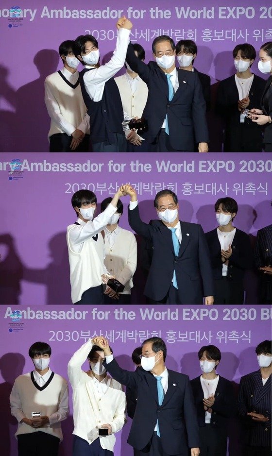BTSメンバーのRM、JIN、SUGAがハン・ドクス（韓悳洙）首相から委嘱牌を受け取り記念写真を撮影する様子（2030釜山万博誘致公式YouTubeのキャプチャー）(c)news1