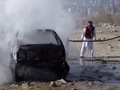 パキスタン北西部・クラム部族地域パラチナルの市場で起きた爆弾事件の現場で炎上した車両の消火にあたる消防隊員（2015年12月13日撮影）。(c)AFP/M SAQLAIN