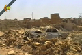2007年8月15日、地元テレビ局が撮影した自爆攻撃を受けたイラク北部Qataniyah村で、がれきに埋もれた自動車。(c)AFP/DSK