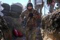 ウクライナ南部ミコライウでロシア軍に爆撃された士官学校付近で塹壕（ざんごう）に向かって走るウクライナ兵（2022年3月19日撮影）。(c)BULENT KILIC / AFP