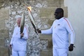 仏マルセイユのノートルダムドラガルド大聖堂で、パリ五輪の聖火リレーを行うサッカー元フランス代表のバジール・ボリ氏（右、2024年5月9日撮影）。(c)CHRISTOPHE SIMON / AFP
